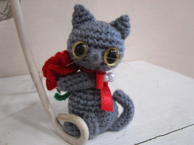 ねこ。カーネーションを持っています。